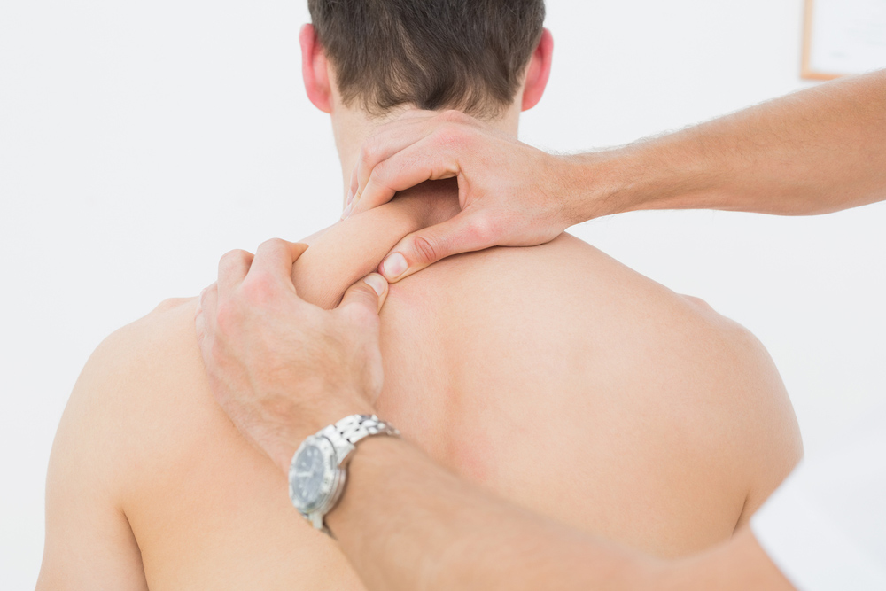 chiropractor massaging a clients shoulder